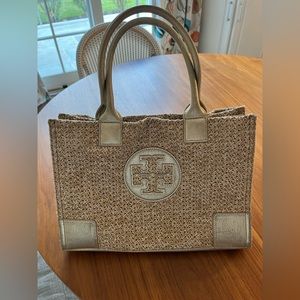 Tory tote in woven macrame with gold leather trim. Wear on bottom and corners